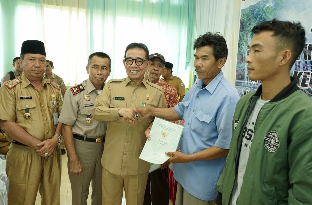 Bupati Hidayatullah saat menyerahkan sertifikat tanah.