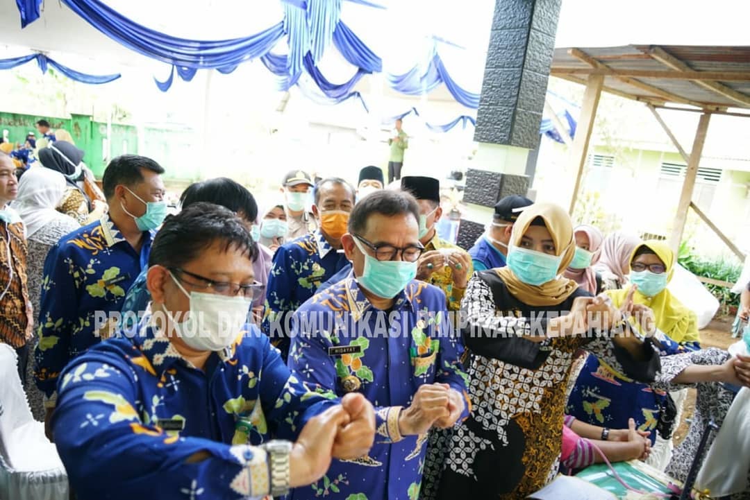 Bupati Hidayatullah saat mencintohkan cara mencuci tangan yang benar.