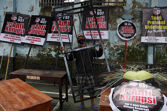 Petugas menyelesaikan dekorasi Tempat Pemungutan Suara (TPS) 037 untuk pelaksanaan Pilkada Solo 2020 di Kampung Bibis Kulon, Banjarsari, Solo, Jawa Tengah, Senin (7/12/2020). TPS dengan tema Anti Korupsi tersebut dibuat untuk meningkatkan partisipasi pemilih - (antarafoto)